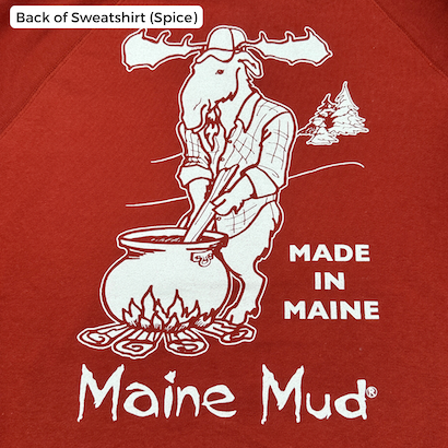 A crewneck in spice red with a moose in a flannel stirring a large pot of caramel over a campfire. The text reads "Made in Maine" and "Maine Mud"